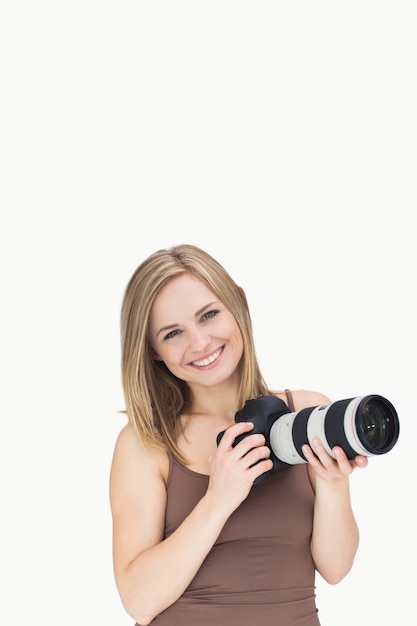 Portrait de femme heureuse avec caméra photographique