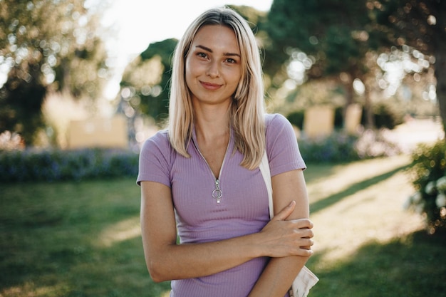 Photo portrait d'une femme heureuse. une femme vêtue d'une robe lumineuse par une journée ensoleillée. femme blonde