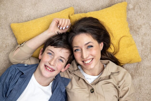 Portrait de femme heureuse avec fils mère et petit ami souriant et regardant la caméra couché ensemble