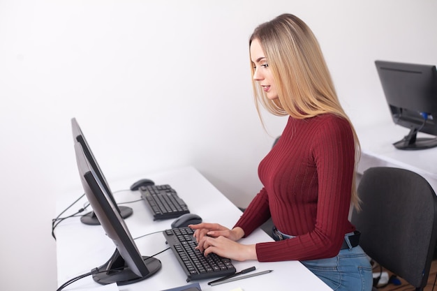 Portrait de femme heureuse jeune femme d&#39;affaires près de mur blanc