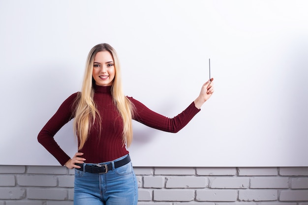 Portrait de femme heureuse jeune femme d'affaires près de mur blanc