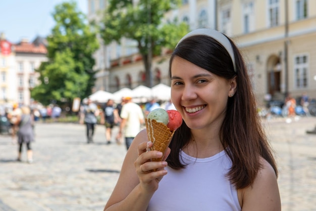 Portrait de femme heureuse mangeant de la glace lors d'une chaude journée d'été à l'extérieur