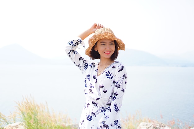 Portrait de femme heureuse porte robe blanche en souriant avec paysage nature