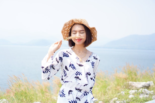 Portrait de femme heureuse porte robe blanche en souriant avec paysage nature