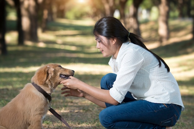 Portrait d&#39;une femme heureuse avec son chien d&#39;or dans le parc.