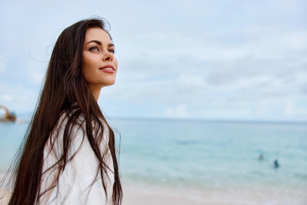 Portrait d'une femme heureuse souriant avec des dents avec des cheveux longs brune voyage d'été et sentiment d'équilibre de liberté