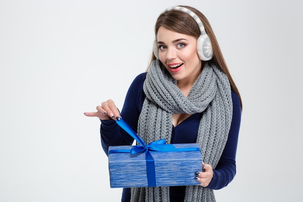 Portrait d'une femme heureuse en tissu d'hiver holding gift box isolé sur fond blanc