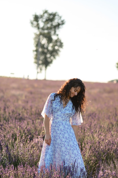 Portrait d'une femme heureuse vêtue d'une robe bleue profitant d'une journée d'été ensoleillée dans un champ de lavande Air frais