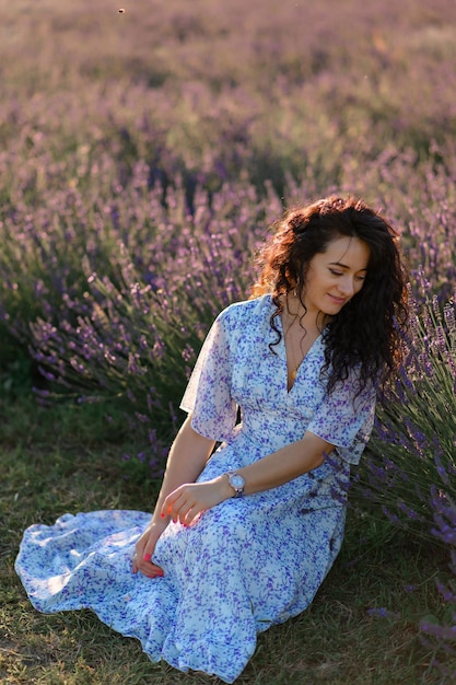 Portrait d'une femme heureuse vêtue d'une robe bleue profitant d'une journée d'été ensoleillée dans un champ de lavande Air frais