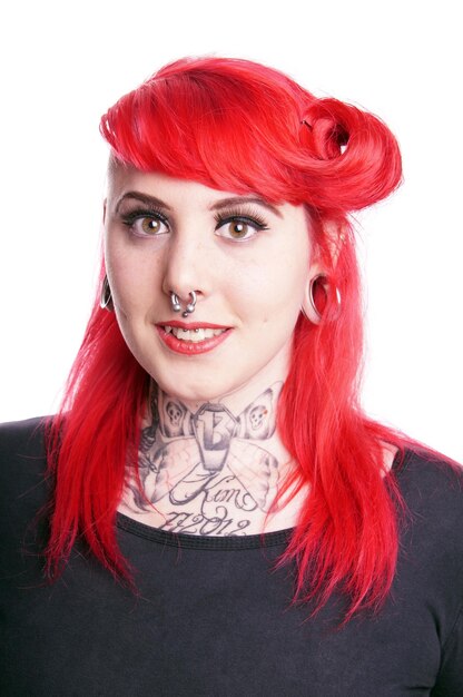 Photo portrait d'une femme hipster avec les cheveux teints et des piercings sur fond blanc