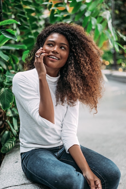 Portrait de femme hispanique heureuse de parler sur smartphone.