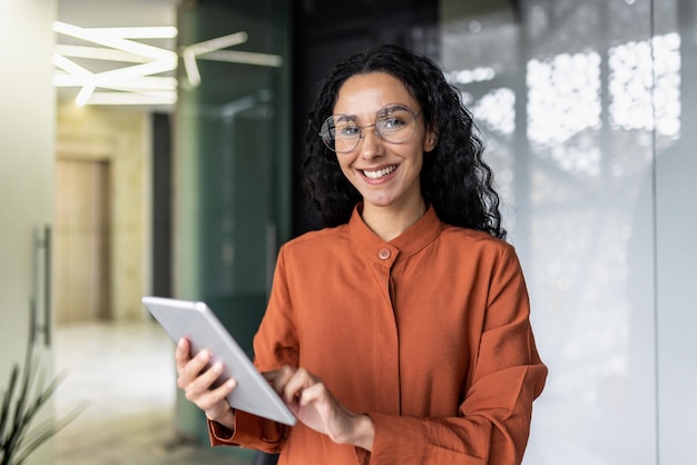 Portrait d'une femme hispanique réussie à l'intérieur du bureau sur le lieu de travail