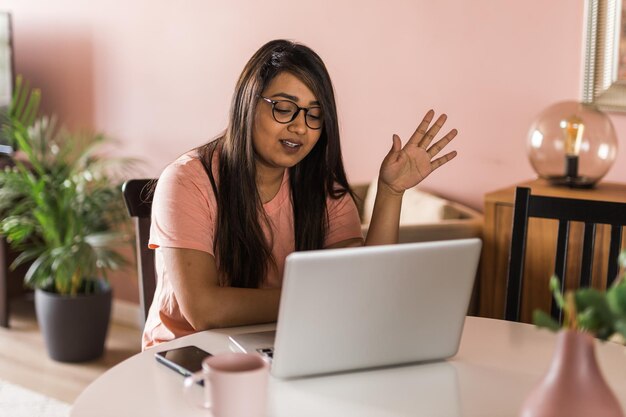 Portrait femme indienne pigiste ou entrepreneur ont une vidéoconférence parlant de travail à distance en ligne à la maison appel vidéo et concept de diversité