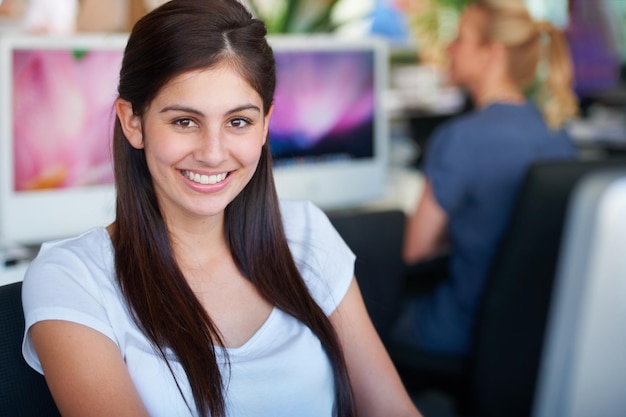 Portrait de femme Indienne et travailleur de démarrage de conception de sites Web avec un sourire amical et heureux au bureau Jeune fille stagiaire dans une agence numérique branchée et moderne pour les graphistes créatifs