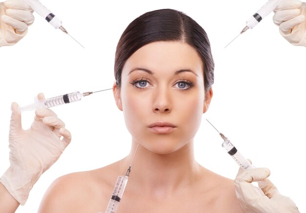 Photo portrait de femme et injection pour la chirurgie plastique en studio avec les mains chimiques et produits par fond blanc chirurgien patient fille et seringue pour la transformation du changement et les résultats avec la beauté