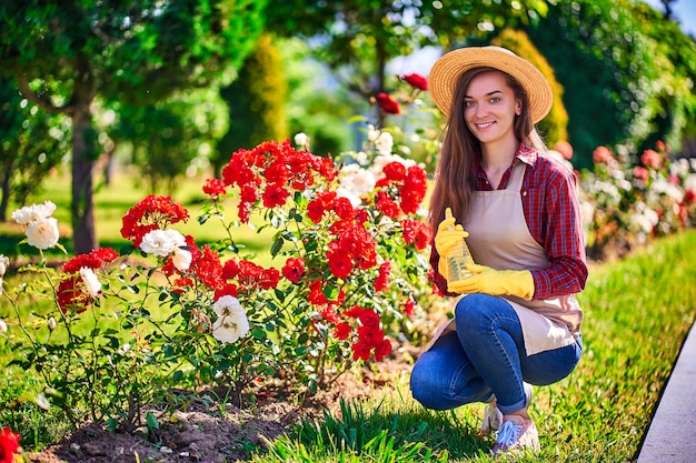 Portrait de femme jardinier arrosant le rosier