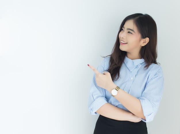 Portrait de femme jeune entreprise asiatique pointant vers le haut sur fond blanc.