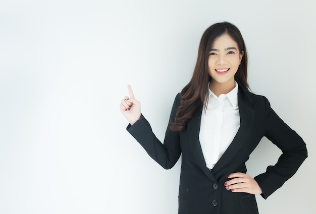 Portrait de femme jeune entreprise asiatique pointant vers le haut sur fond blanc.