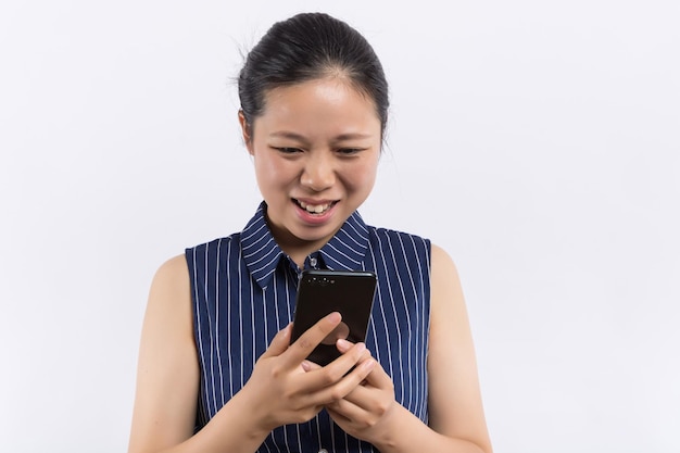 Portrait d'une femme joyeuse montrant un écran de smartphone vierge sur fond jaune