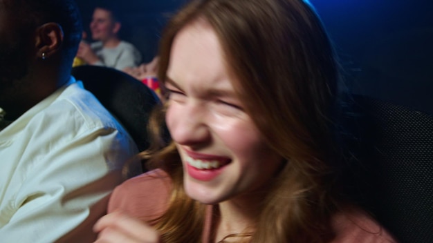 Portrait d'une femme joyeuse regardant un film drôle au cinéma Gros plan fille heureuse riant dans une salle de cinéma Modèle féminin joyeux s'amusant à l'intérieur