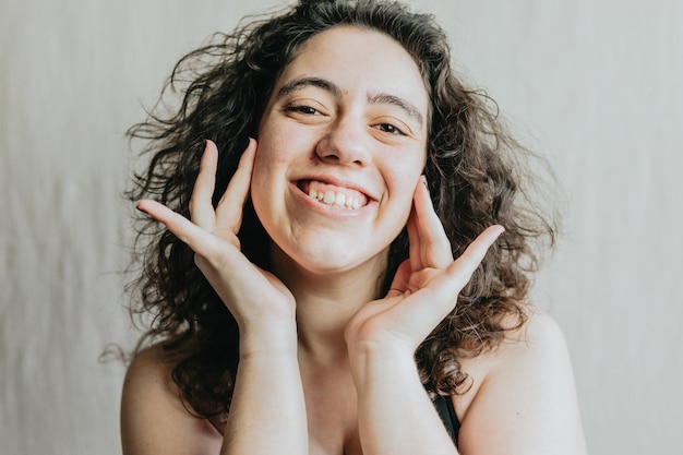 Portrait d'une femme joyeuse avec ses mains sur son visage exprimant le bonheur