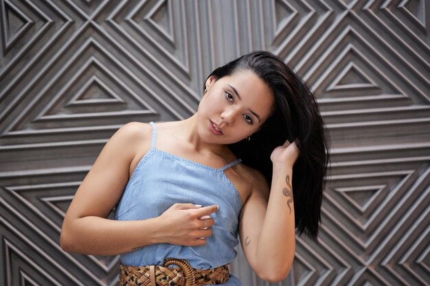 Portrait d'une femme latina aux cheveux longs jeune femme hispanique touchant ses cheveux avec sa main