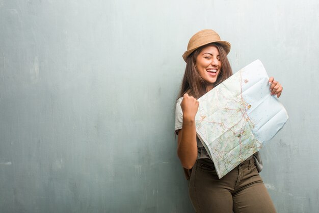 Portrait de femme latine jeune voyageur contre un mur très heureux et excité