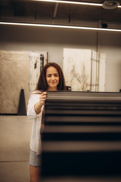 Portrait d'une femme latine joyeuse qui cherche à acheter de nouveaux carreaux pour sa cuisine au magasin de plancher