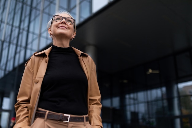 Portrait d'une femme leader charismatique adulte mature réussie sur fond de verre