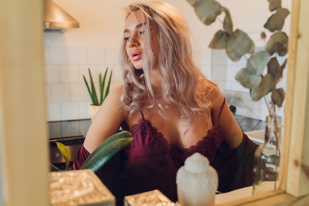 Portrait d'une femme en lingerie posant dans la cuisine.