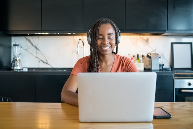 Portrait d'une femme lors d'un appel vidéo avec ordinateur portable tout en travaillant à domicile.