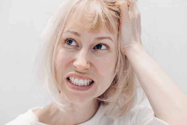 Portrait d'une femme avec un mal de tête sur fond blanc