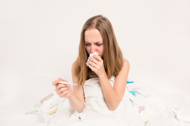 Portrait de femme malade avec fièvre et nez qui coule tenant un thermomètre