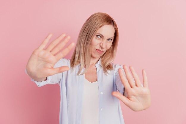 Portrait d'une femme malheureuse de mauvaise humeur montrant un geste d'arrêt de la paume refuser le déclin isolé sur fond de couleur rose