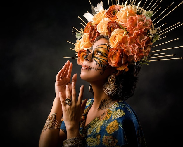 Portrait d'une femme avec un maquillage de crâne en sucre Catrina avec un papillon peint sur son visage