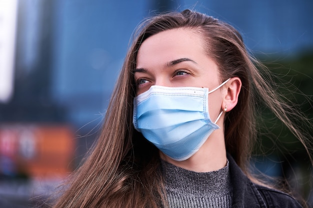 Portrait de femme en masque de protection médical à l'extérieur. Protection de la santé lors d'une épidémie de virus grippal, de maladies infectieuses épidémiques et de pollution de l'air dans la ville. Arrêtez le coronavirus et le nouveau covid ncov