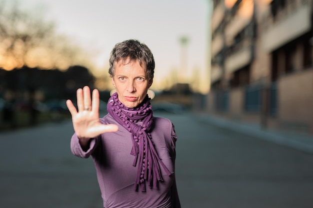 Photo portrait d'une femme mature faisant des gestes alors qu'elle se tient à l'extérieur