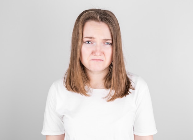 Portrait de femme mécontente bouleversée face à pleurer, isolé sur fond gris studio.