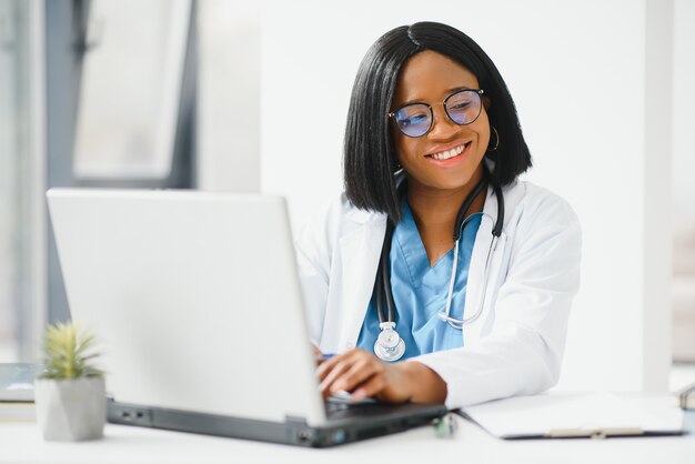 Portrait de femme médecin afro-américaine souriant à l'hôpital