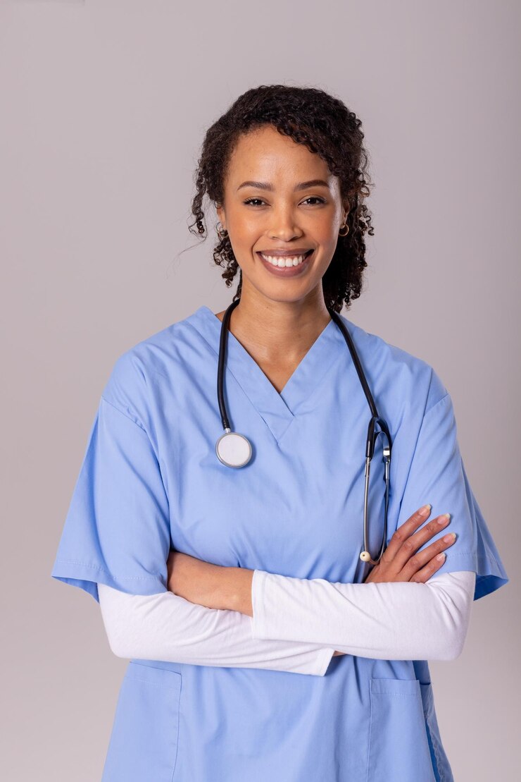 Photo portrait d'une femme médecin afro-américaine souriante, mi-adulte, les bras croisés sur fond blanc. espace de copie, stéthoscope, médecin, concept médical, de soins de santé, d'hôpital et de profession médicale.