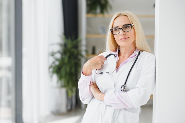 Portrait d'une femme médecin d'âge moyen porte une blouse de médecin blanche avec un stéthoscope autour du cou Médecin souriant debout dans une clinique privée