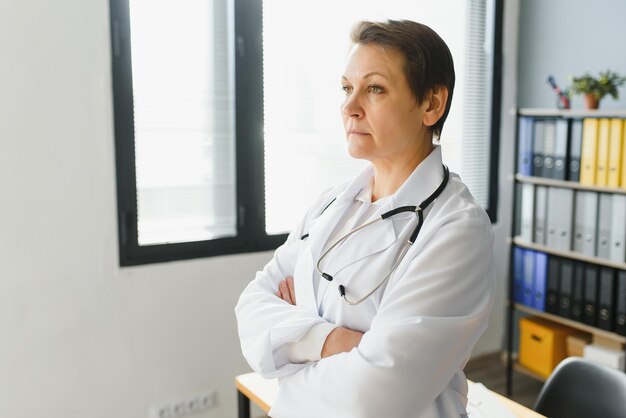 Portrait d'une femme médecin d'âge moyen porte une blouse de médecin blanche avec un stéthoscope autour du cou