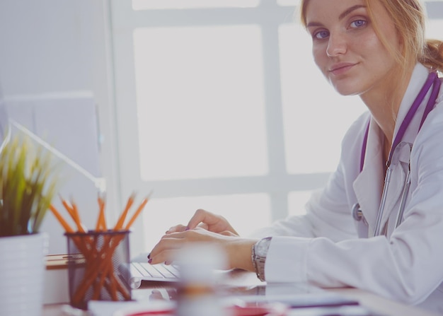 Portrait d'une femme médecin à l'aide de son ordinateur portable à la clinique