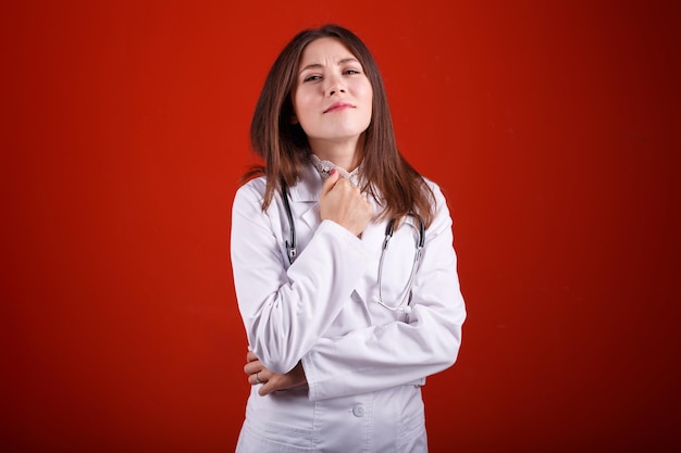 Portrait d'une femme médecin sur fond rouge
