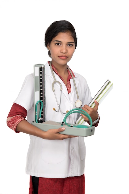 Portrait d'une femme médecin avec instrument de pression artérielle et stéthoscope sur espace blanc.