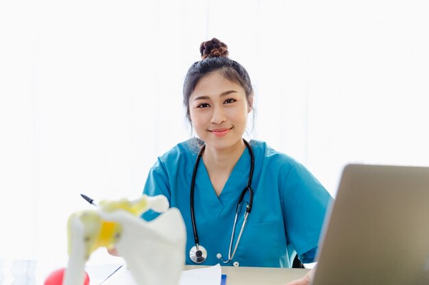 Portrait, femme médecin, séance, travailler, note, presse-papiers, cabinet médical