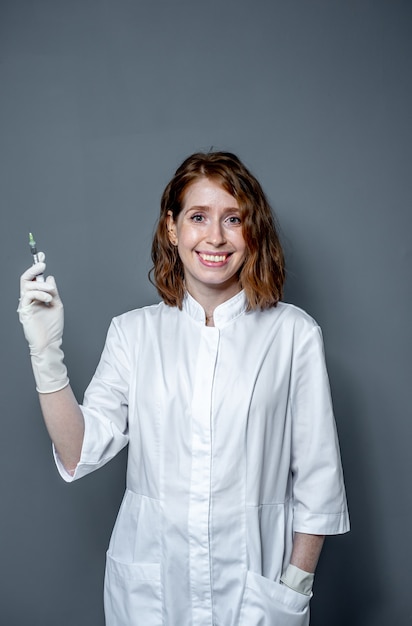 Portrait d'une femme médecin avec une seringue dans ses mains