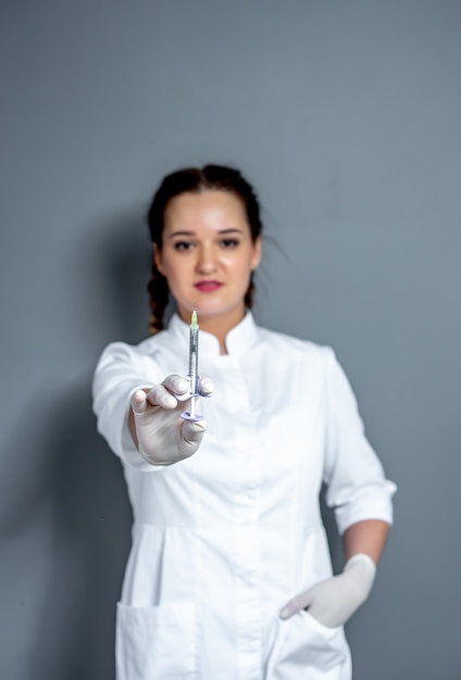 Portrait d'une femme médecin avec une seringue dans ses mains