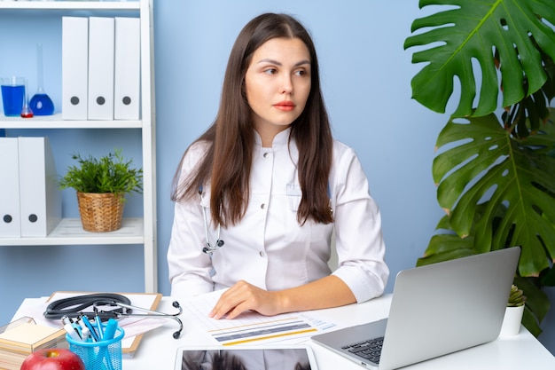 Portrait de femme médecin à son bureau, intérieur de bureau