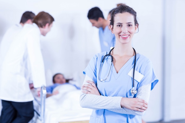 Portrait De Femme Médecin Souriant Et Autre Médecin Examinant Un Patient Derrière